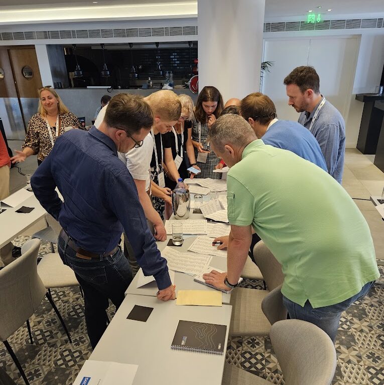 a group of people standing around a table with papers